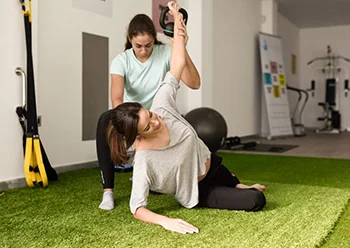 A woman is lifting a kettlebell