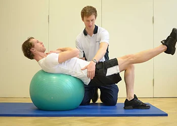 A man lies on a blue exercise ball